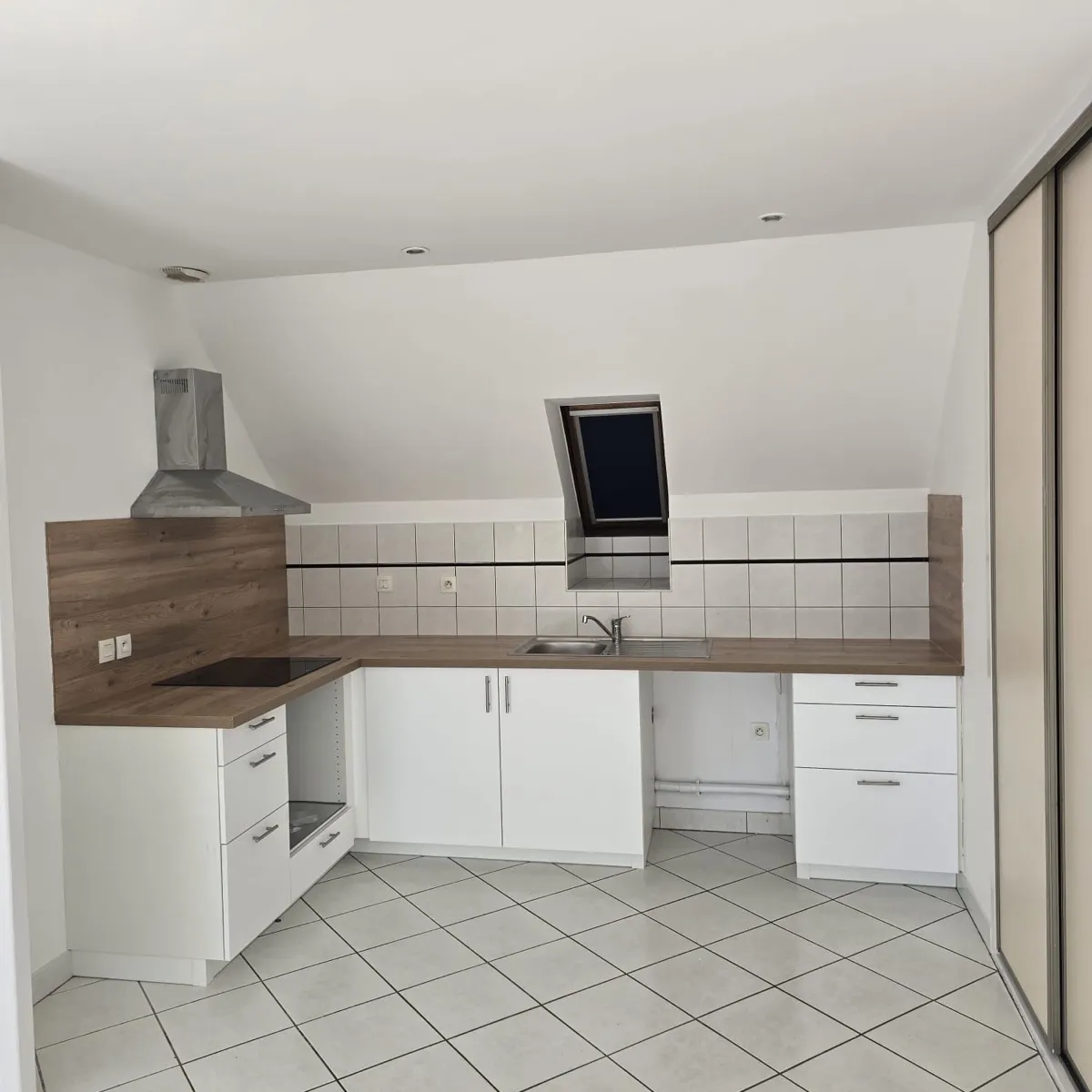 Cuisine aménagée blanche avec plan de travail bois après rénovation de l'appartement à Blois