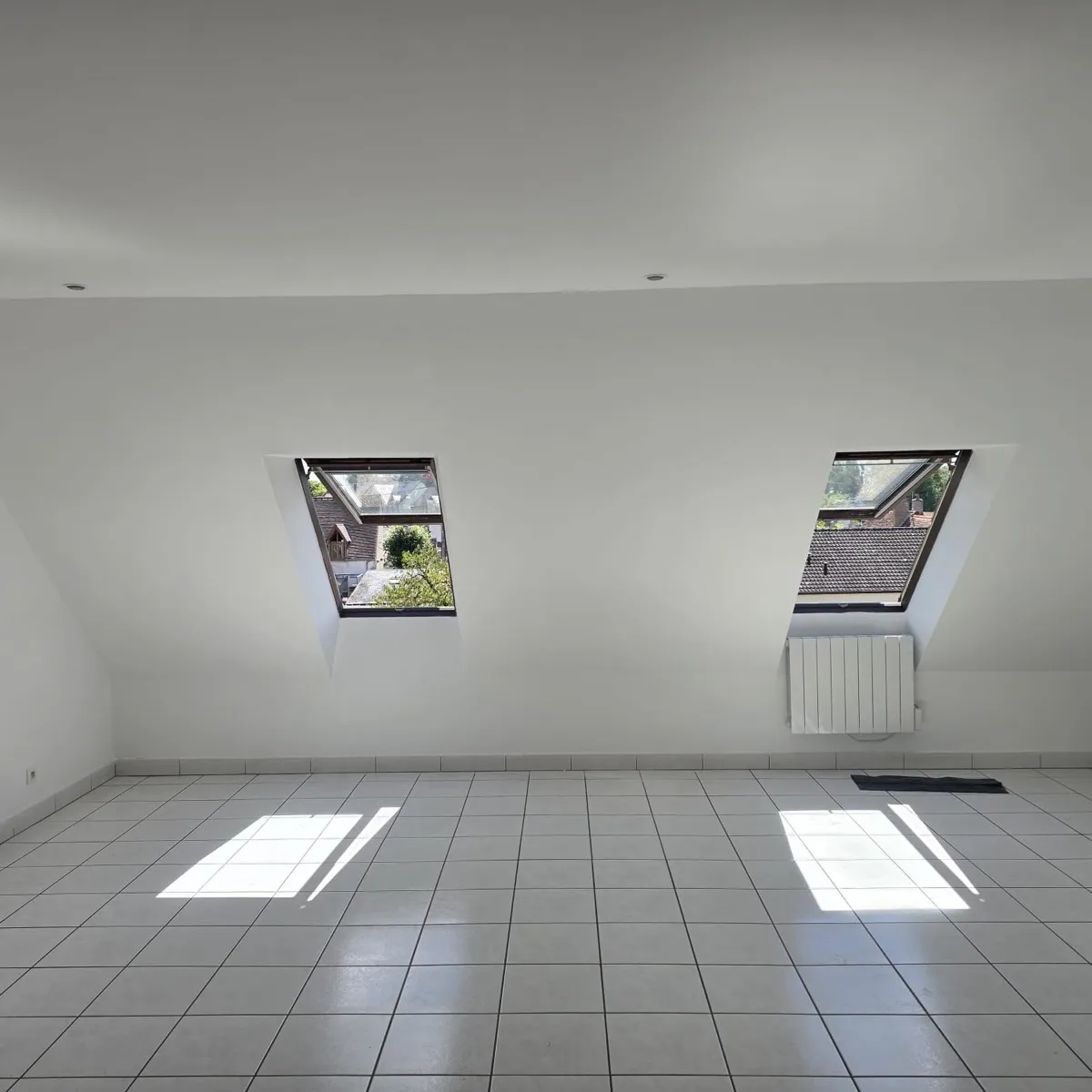 Séjour sous combles repeint en blanc avec velux, après rénovation par Rénovation41 à Blois