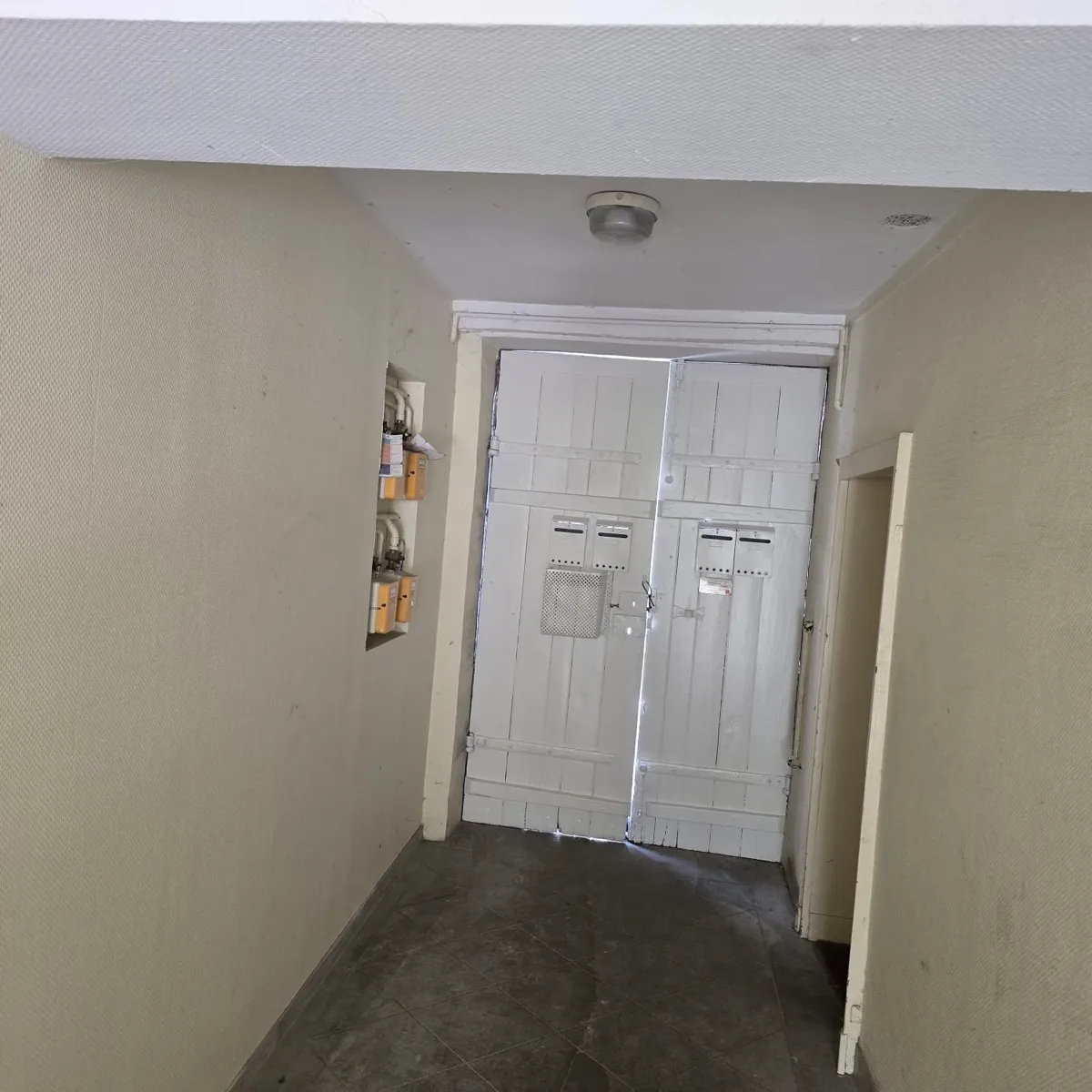Porte d'entrée d'immeuble repeinte en blanc après rénovation par Rénovation41