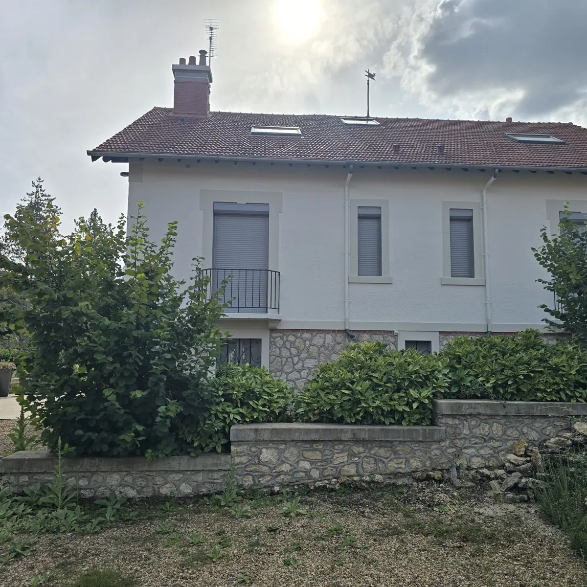 Villa avec façades repeintes en blanc et soubassement en pierre, côté jardin, peinture extérieure dans le Loir-et-Cher